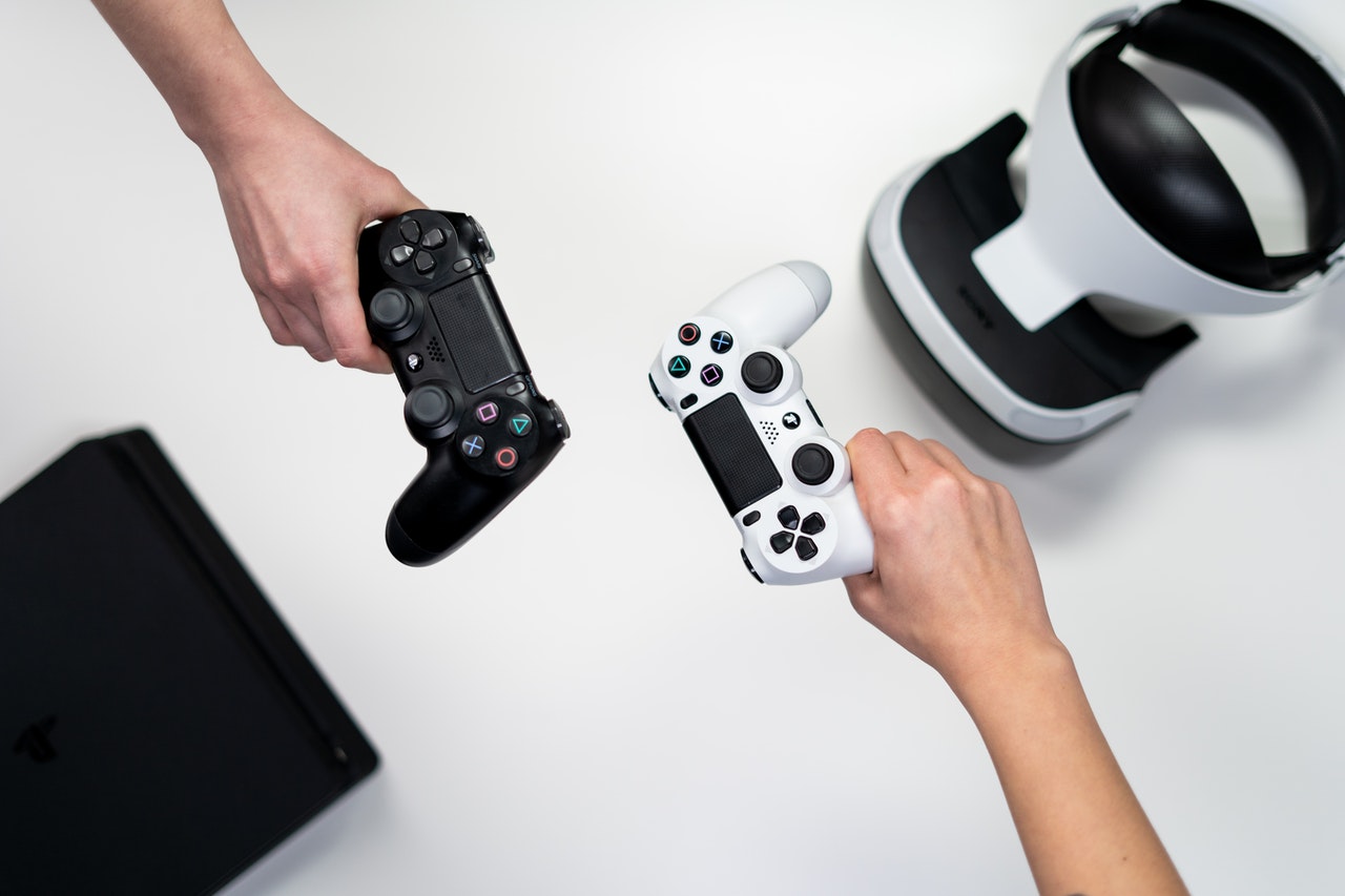 A person holding white and black xbox one game controller