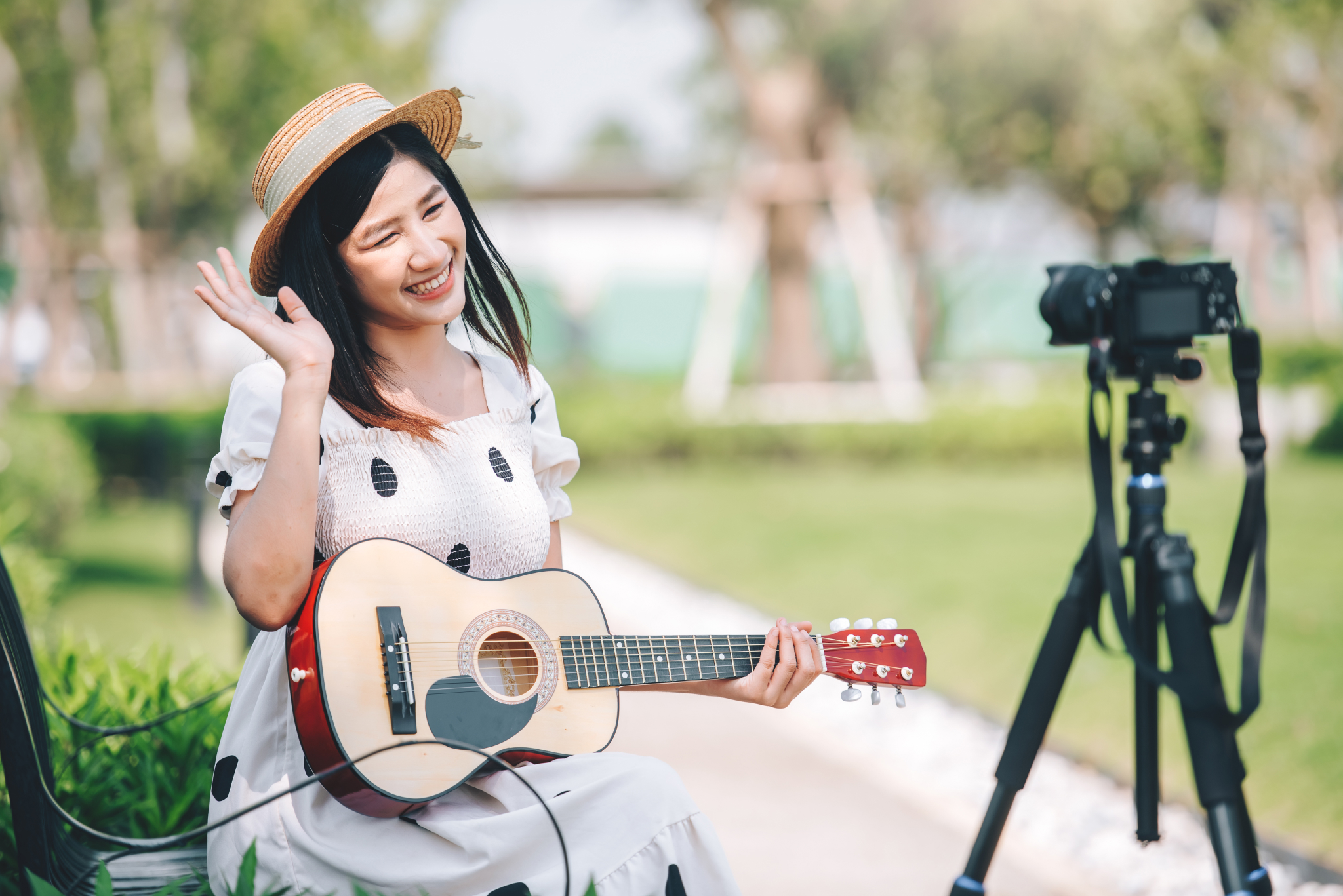asian-woman-influencer-playing-guitar-in-the-park-2023-06-15-22-39-45-utc 1